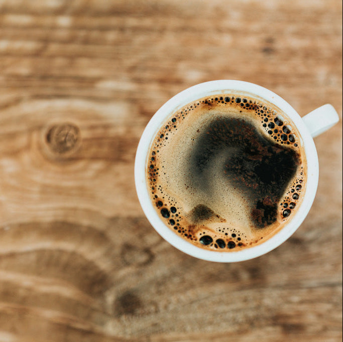 cup of rumor has it flavored hand-roasted coffee on a wooden counter in northeast iowa