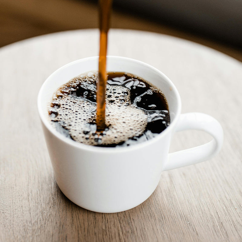 cup of coffee brewed with rumor has it flavored coffee beans